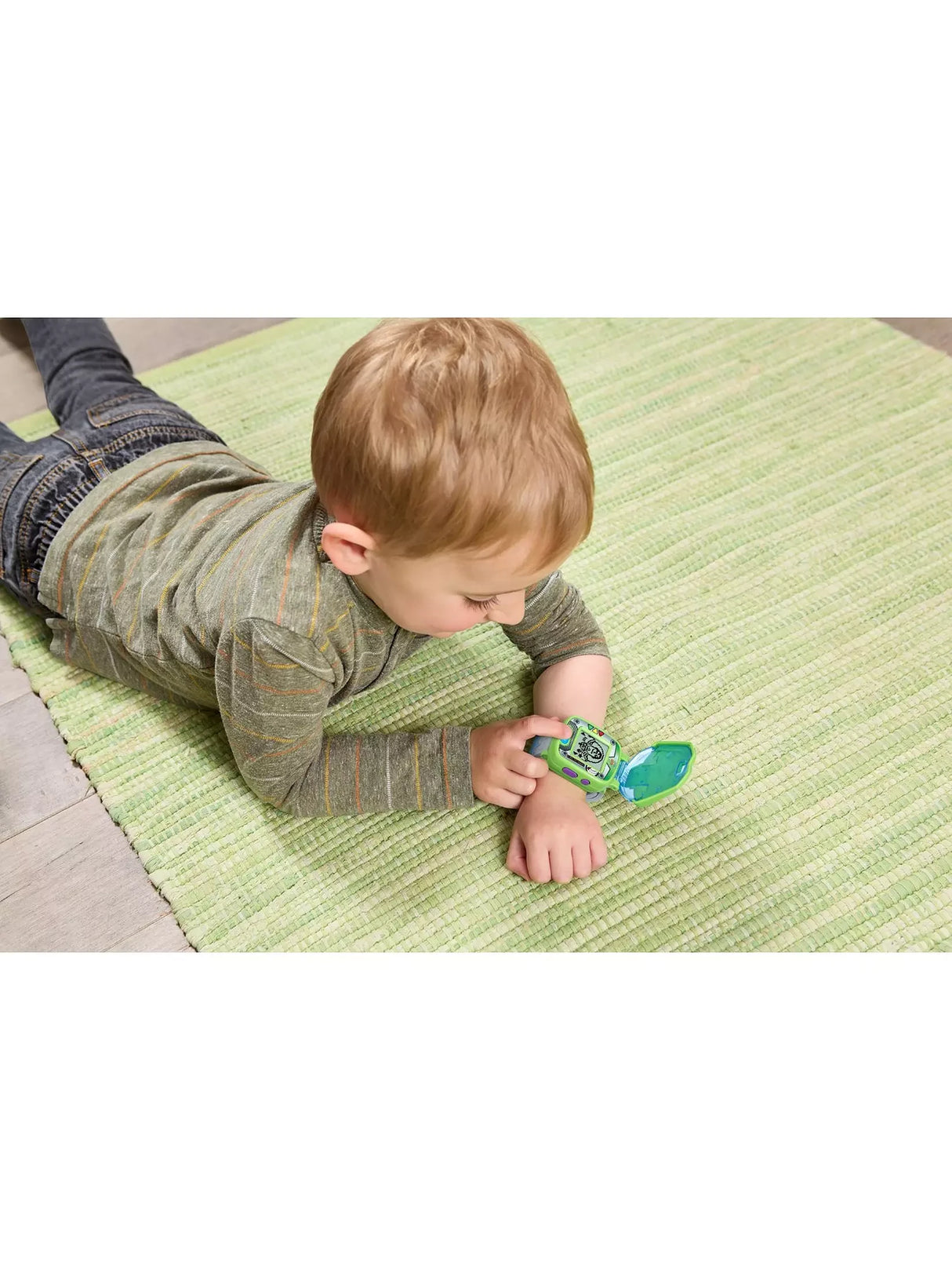 Child wearing VTech Disney Pixar Toy Story 5 Buzz Lightyear Learning Watch on wrist while lying on green rug