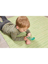 Child wearing VTech Disney Pixar Toy Story 5 Buzz Lightyear Learning Watch on wrist while lying on green rug