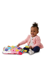 Toddler sitting and playing with the detachable activity panel from the VTech First Steps Baby Walker