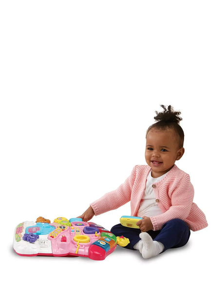 Toddler sitting and playing with the detachable activity panel from the VTech First Steps Baby Walker