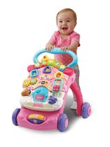 Baby smiling while learning to walk using the VTech First Steps Baby Walker pink version