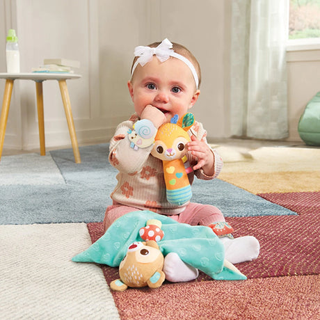 Baby sitting on rug with VTech Forest Pals First Discoveries Set comforter and fawn rattle