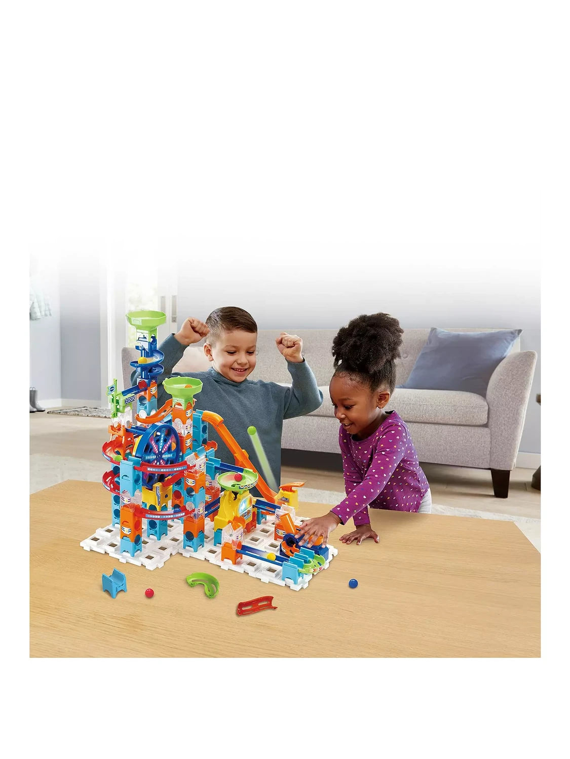 Children playing with the VTech Marble Rush Adventure Set built with tall towers, ramps, funnels and Ferris wheel
