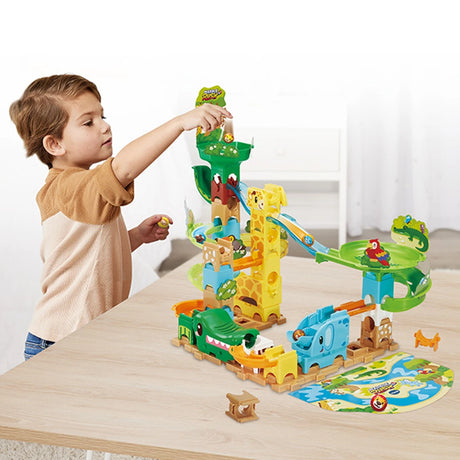 Child at table with VTech Marble Rush Junior Safari Slides track layout and animal marbles