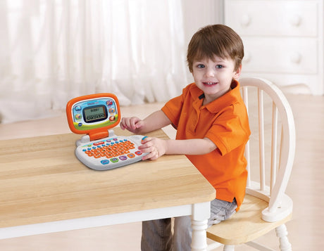 Child sitting at a table with VTech My Laptop open in front of them