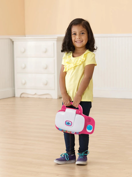Child carrying closed VTech My Laptop Pink by the handle