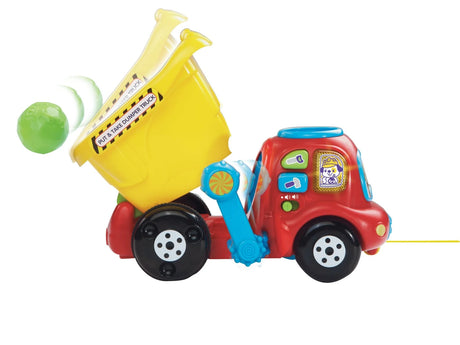 VTech Put & Take Dumper Truck with yellow tipper bed raised and green rock beside the truck
