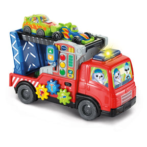 Angled front side view of VTech Road Rescue Car Carrier showing red cab, flashing roof light, interactive panel and two cars on upper deck