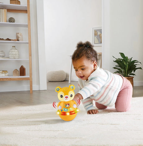 Child crawling beside VTech Rock and Roll Bear with light-up base