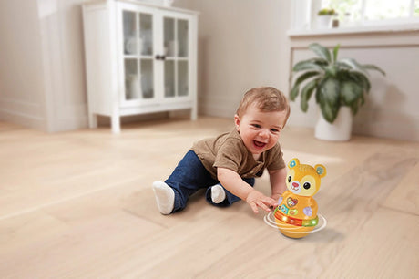 Child sitting beside VTech Rock and Roll Bear with light-up base
