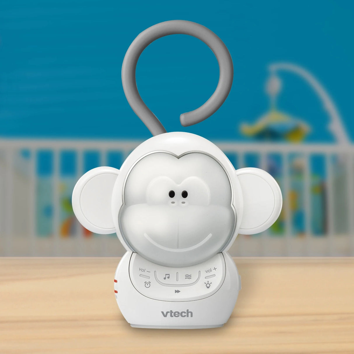 VTech Myla the Monkey Portable Soother standing on a table with a cot visible in the background