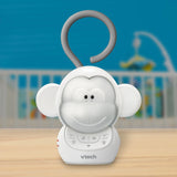 VTech Myla the Monkey Portable Soother standing on a table with a cot visible in the background