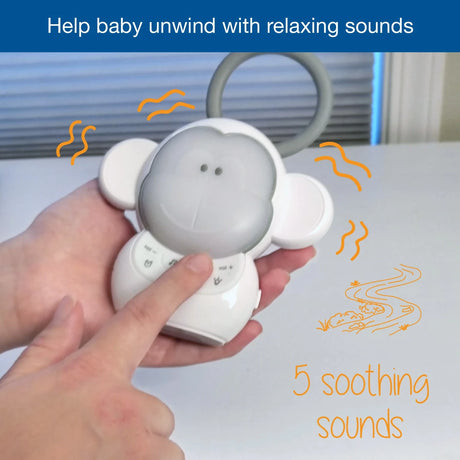 Hand pressing the VTech Myla the Monkey Portable Soother controls with a 5 soothing sounds graphic