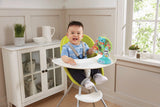 Child seated in a highchair with the VTech Sing-Along Spinning Wheel attached to the tray