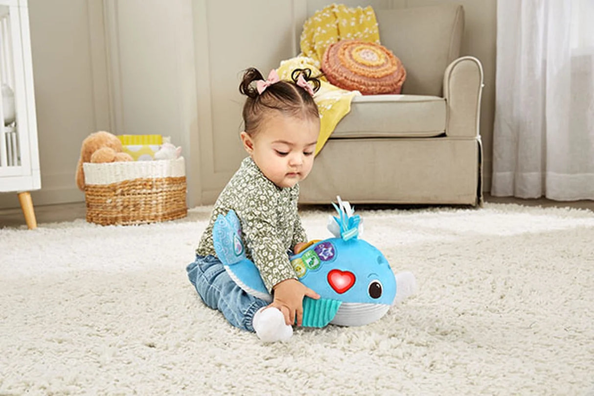 Baby playing with VTech Snuggly Sounds Whale toy on carpet – Ireland