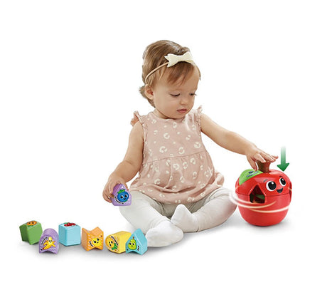 Child sitting beside VTech Sorting Fun Apple with fruit blocks
