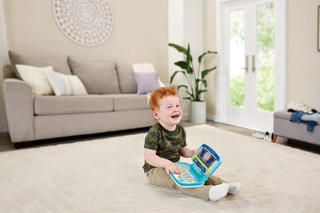 Child playing with VTech Swipe and Learn Laptop on floor – Ireland.