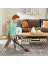 VTech Tidy Up Vacuum with a child in a green top holding the stick vacuum over a patterned rug