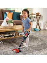 VTech Tidy Up Vacuum with a child using the stick vacuum on a patterned rug in a living room