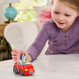 Child pushing the VTech Toot-Toot Drivers Bluey Escape Convertible across a table with its front lights on