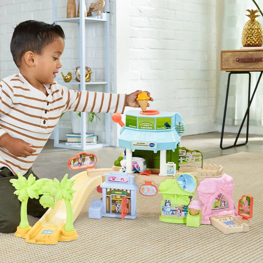 Child placing an orange ice cream cone into the dispenser on the VTech Bluey Ice Cream Adventure Play Set