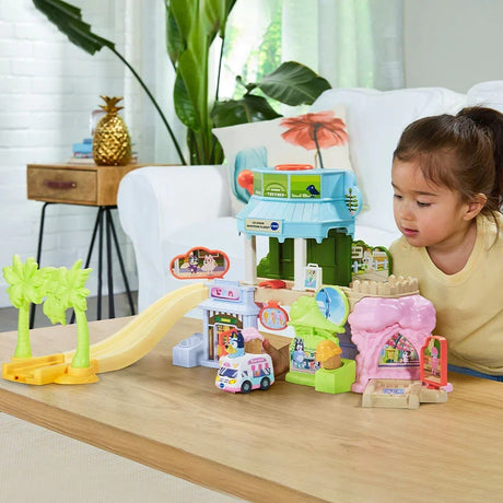 Child playing with the VTech Bluey Ice Cream Adventure Play Set and Ice Cream Truck on a wooden table