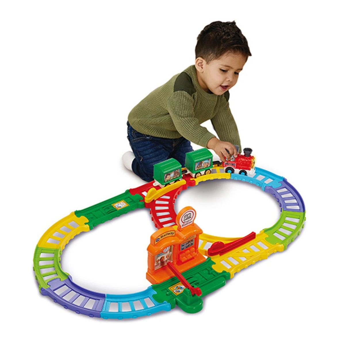 Young child kneeling on the floor playing with the Toot-Toot train set, pushing the red engine along the colourful track in front of them.