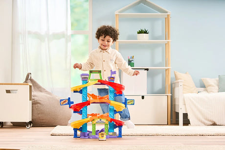 Child behind VTech Toot-Toot Drivers Criss-Cross Raceway in a bedroom with the yellow car at the front