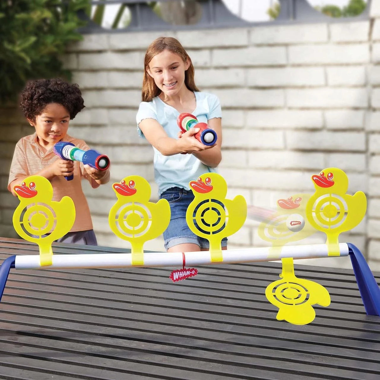 Children playing Wham-O Game Time Carnival Duck Shoot target game outdoors