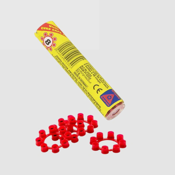 Wicke 8 Shot Ring Caps yellow tube placed diagonally with multiple red 8 shot ring caps on light grey background
