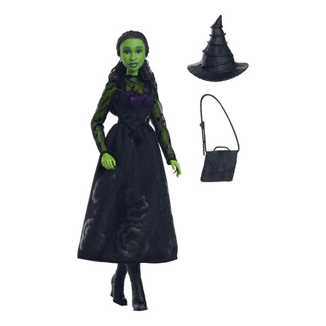 Elphaba doll standing with green skin and braid, alongside hat, boots, and school bag on white background