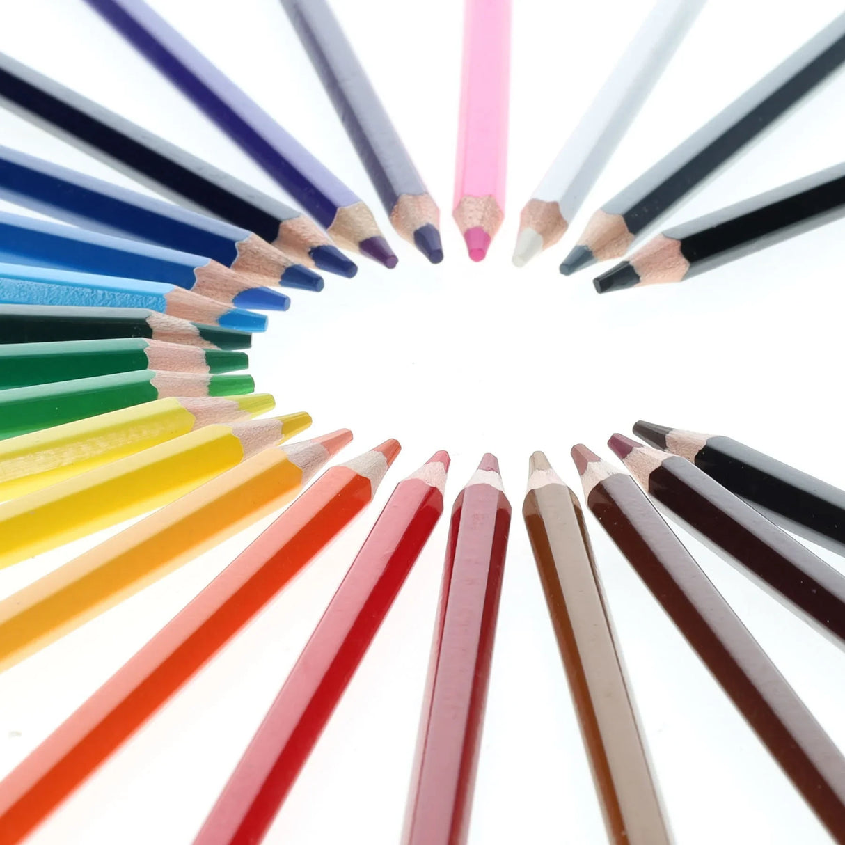 Close-up of assorted World of Colour colouring pencils arranged in a circle with sharpened tips pointing inward