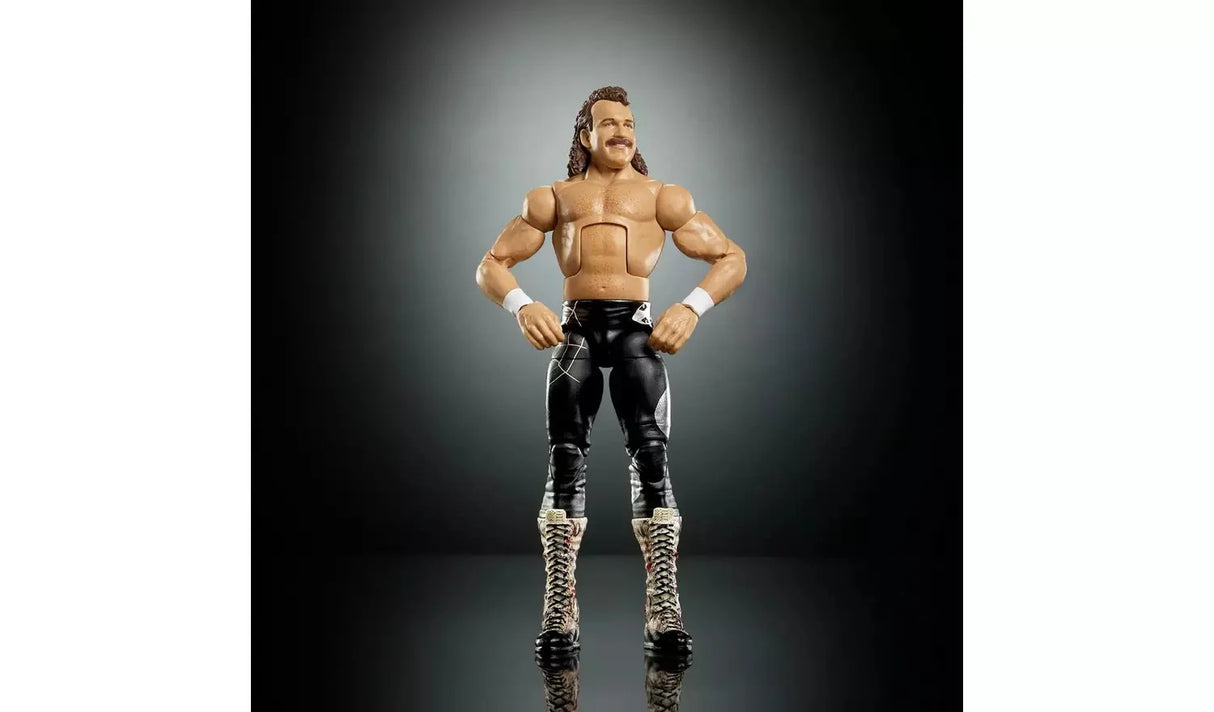 WWE WrestleMania Elite Jake The Snake Roberts action figure front-facing view in black trunks and lace-up boots with white wristbands, hands on hips pose