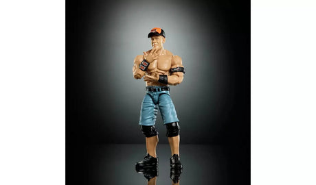 WWE WrestleMania Elite John Cena action figure front view in blue shorts and orange cap with wristbands, posed with a salute gesture