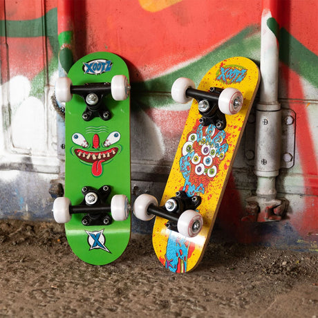Two Xootz mini skateboards shown upright with green and yellow underside graphics