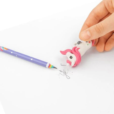 Hand using the unicorn eraser from the Ylvi Rainbow Pencil Set on pencil marks