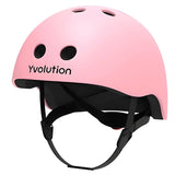 Pink Yvolution kids helmet angled view showing shell shape, vents, and strap system